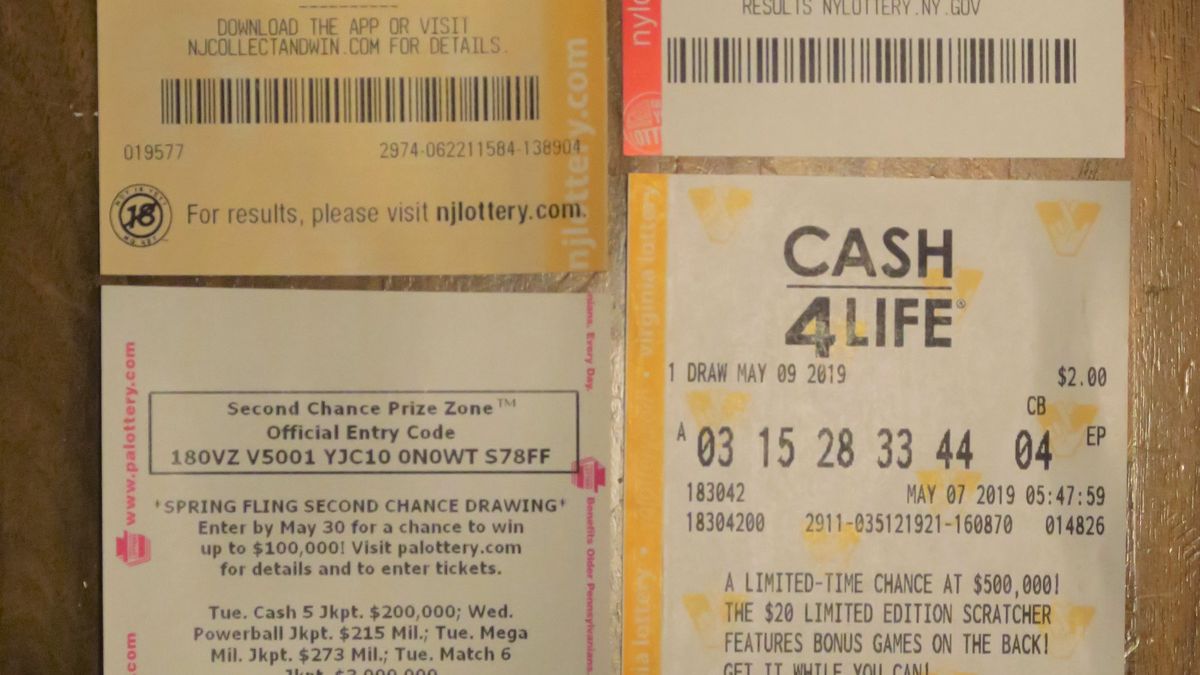 Several Cash4Life draw lottery tickets laid out side by side on a wooden table