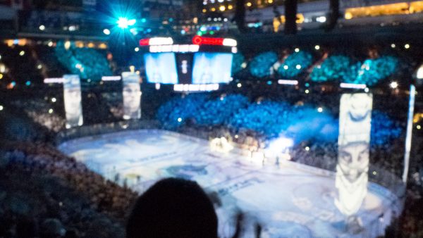 NHL playoff game at Rogers Arena in Vancouver seen from the upper stands, rink lit under the scoreboard