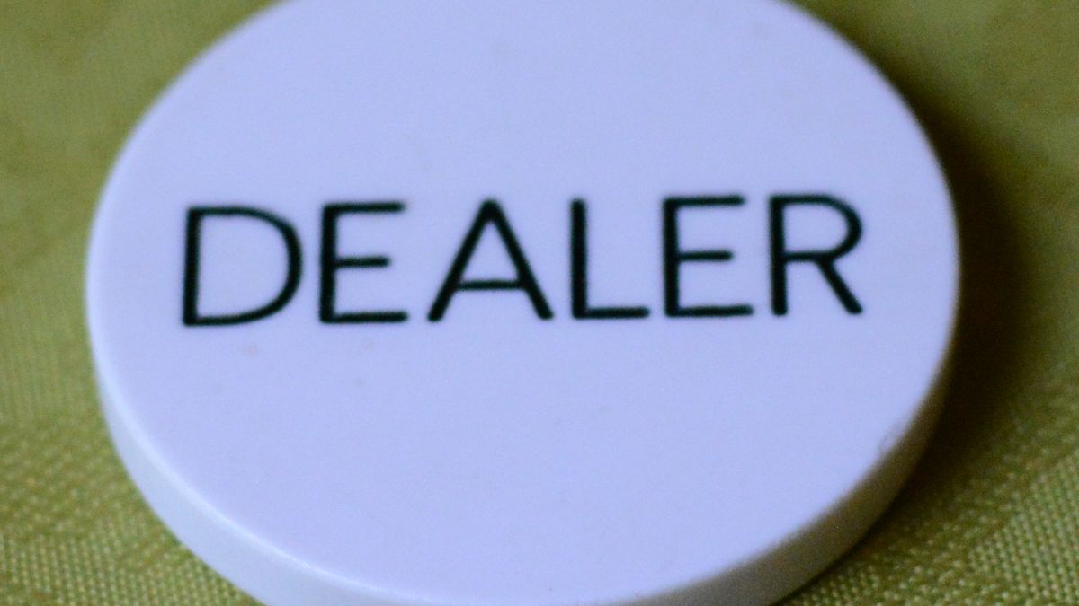 White poker dealer button lying on green felt